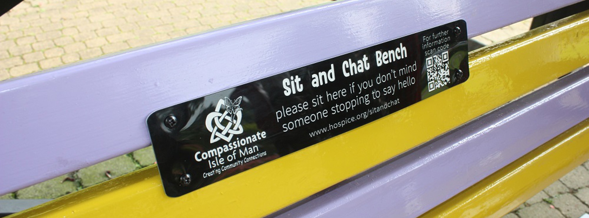 A close up photo of the plaque on a Sit and Chat bench