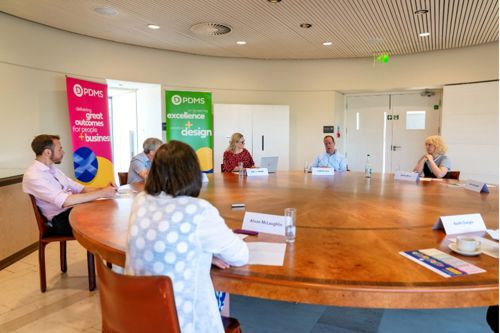 A group of people talking at roundtable