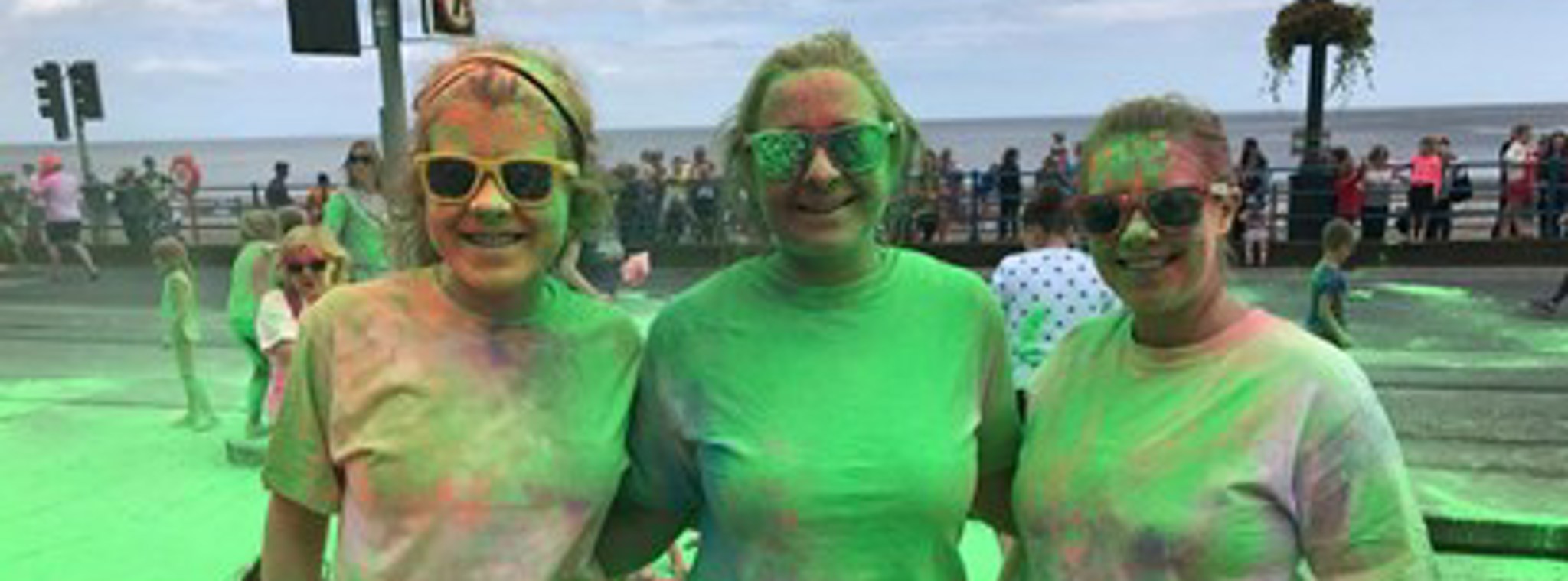Kiera, Hannah and Carla covered in green paint as part of the Hospice's Colour Me Rainbow fun-run