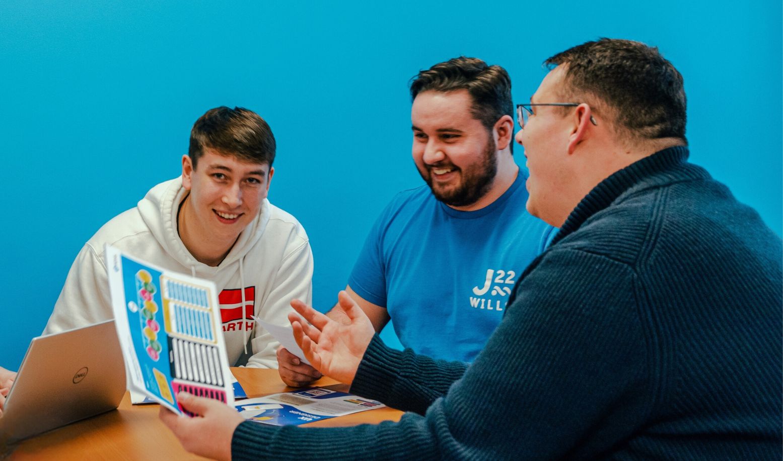  Three men laughing around a table