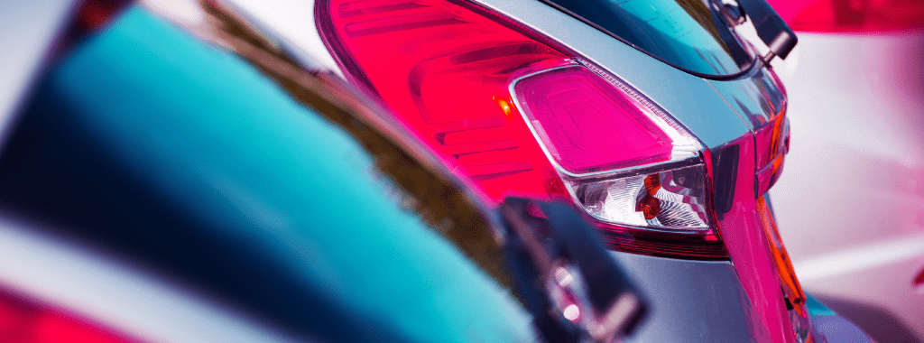 A close-up image of rear lights on parked cars