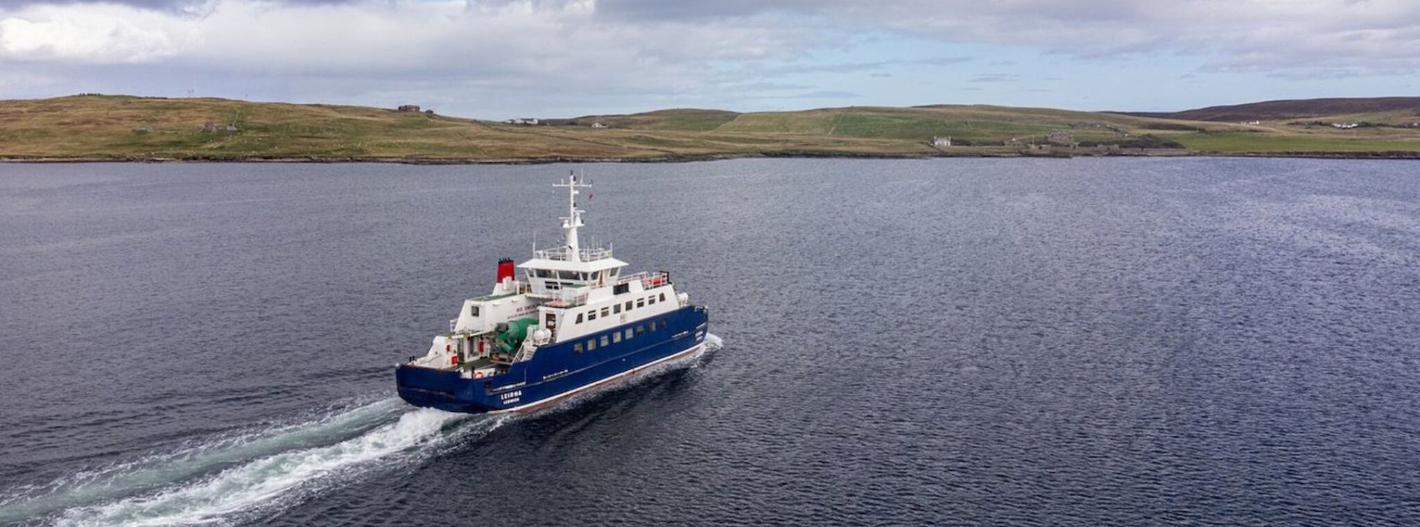 An image of a Shetland Islands Council ferry at sea approaching the mainland