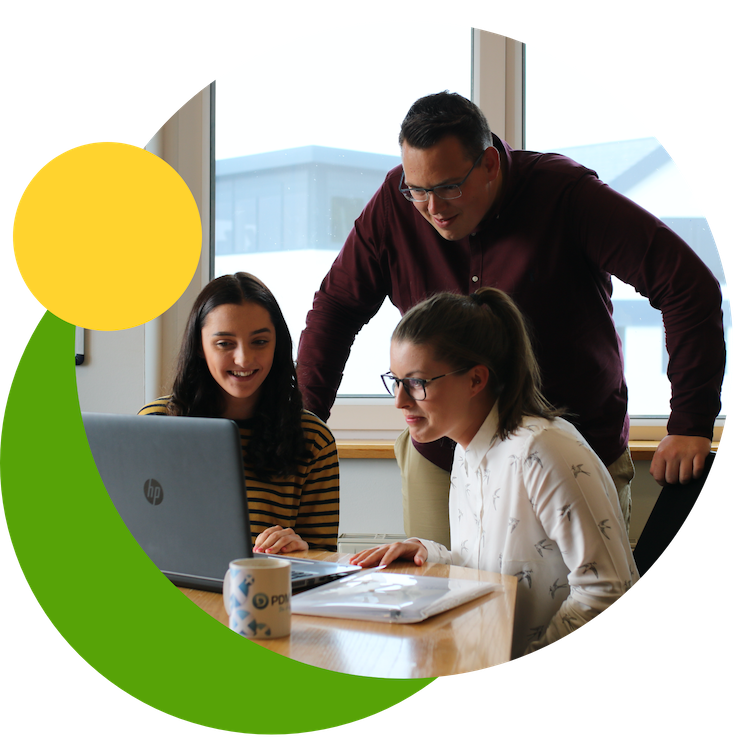 an image of three PDMS employees gathered round a laptop, all smiling