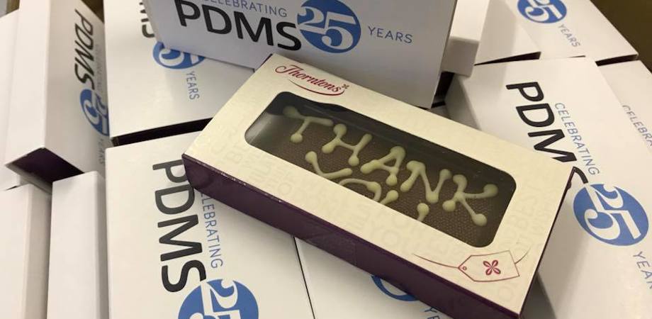 Photo of PDMS-branded chocolates in boxes that read 'Celebrating 25 years PDMS'
