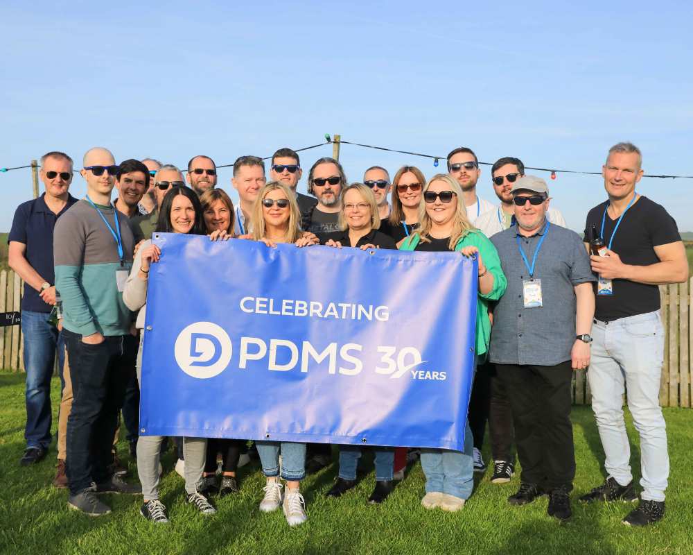 Scotland team smiling and holding banner reading 'Celebrating PDMS 30 Years'