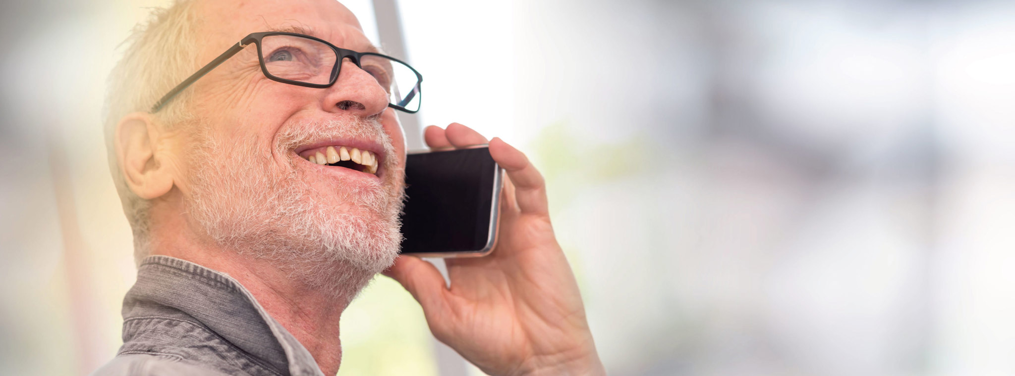 A photo of a man sat with a mobile phone to his ear