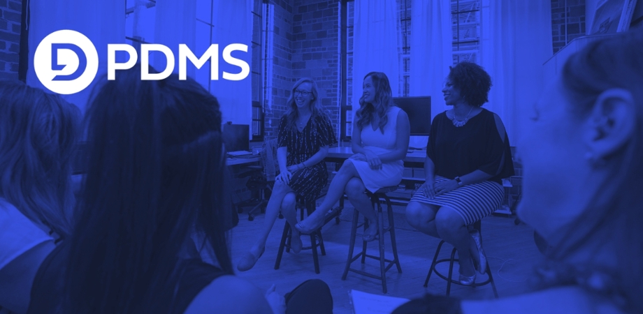 Photo of three women presenting to a room of female attendees with the PDMS logo overlaid