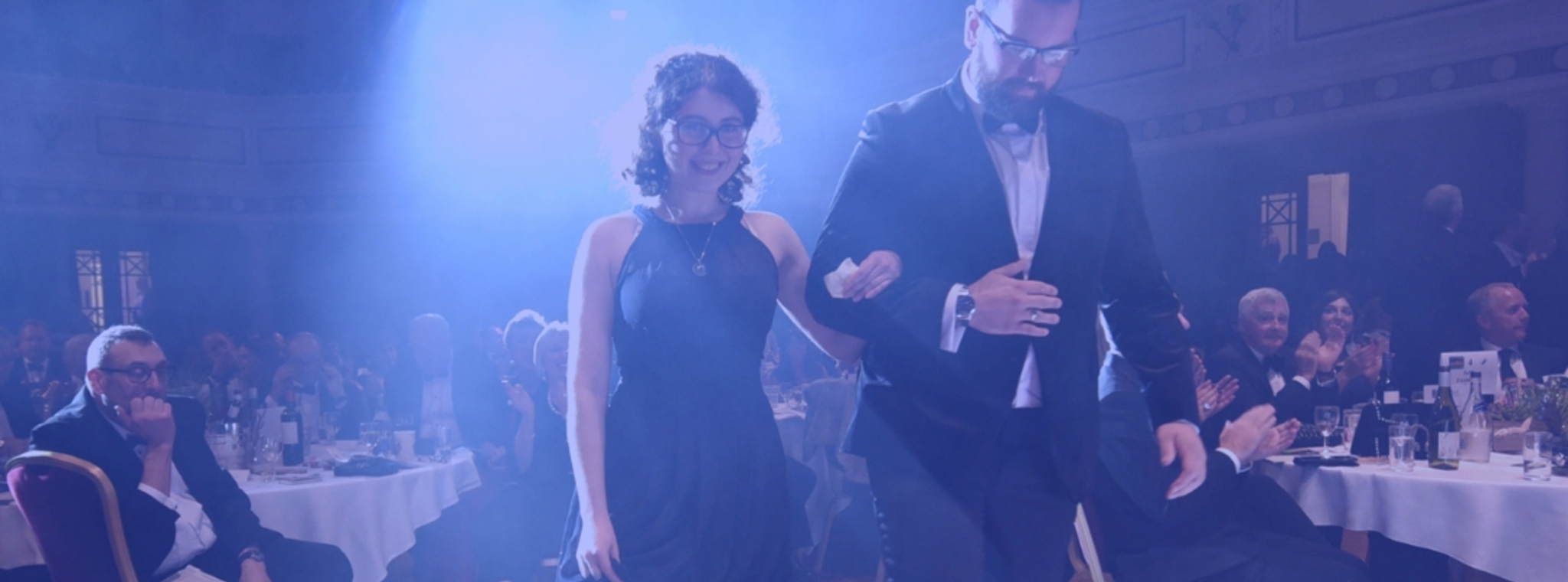 A photo of Alexandra walking on stage to collect her award