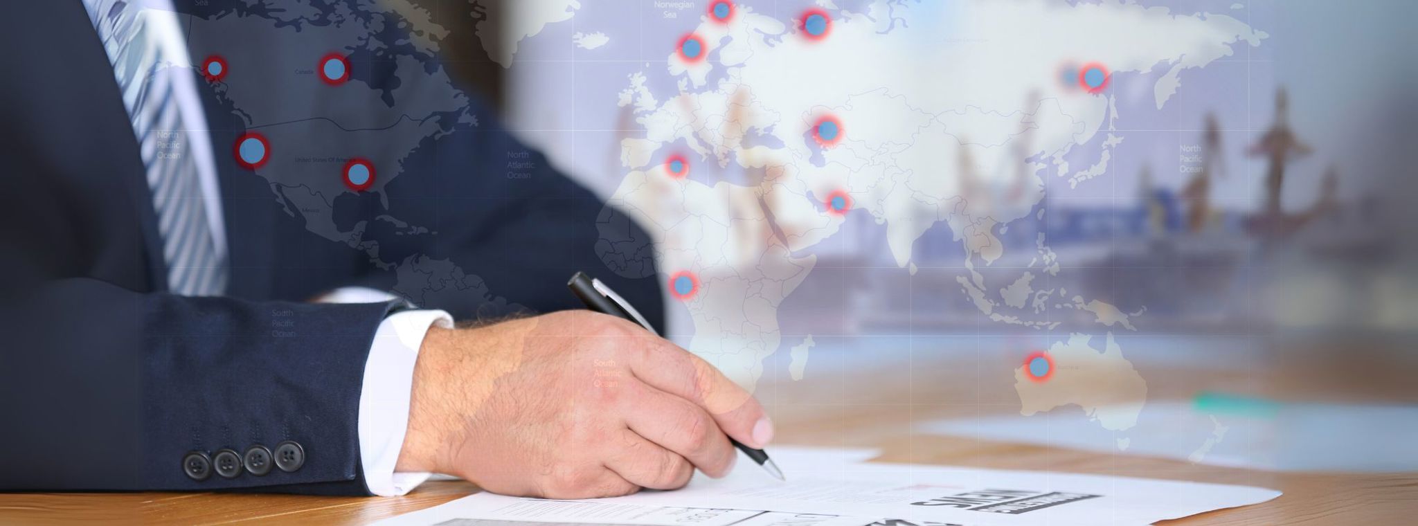 A businessman signing documents with a digital world map overlaid and a shipyard in the background