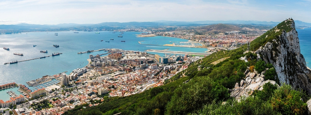 A panoramic photo of the rock of Gibraltar with the marina behind it