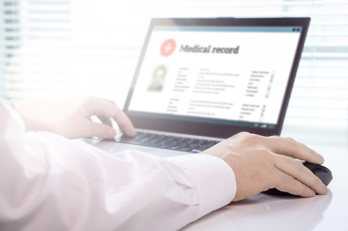 Doctor looking at medical record on computer