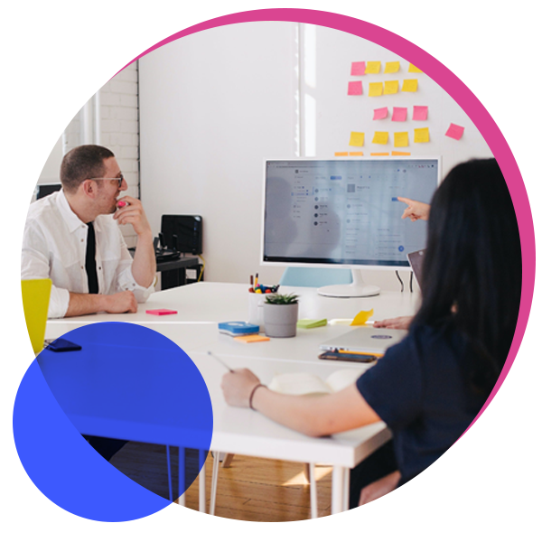 A photo of a group of people working in a boardroom with a whiteboard