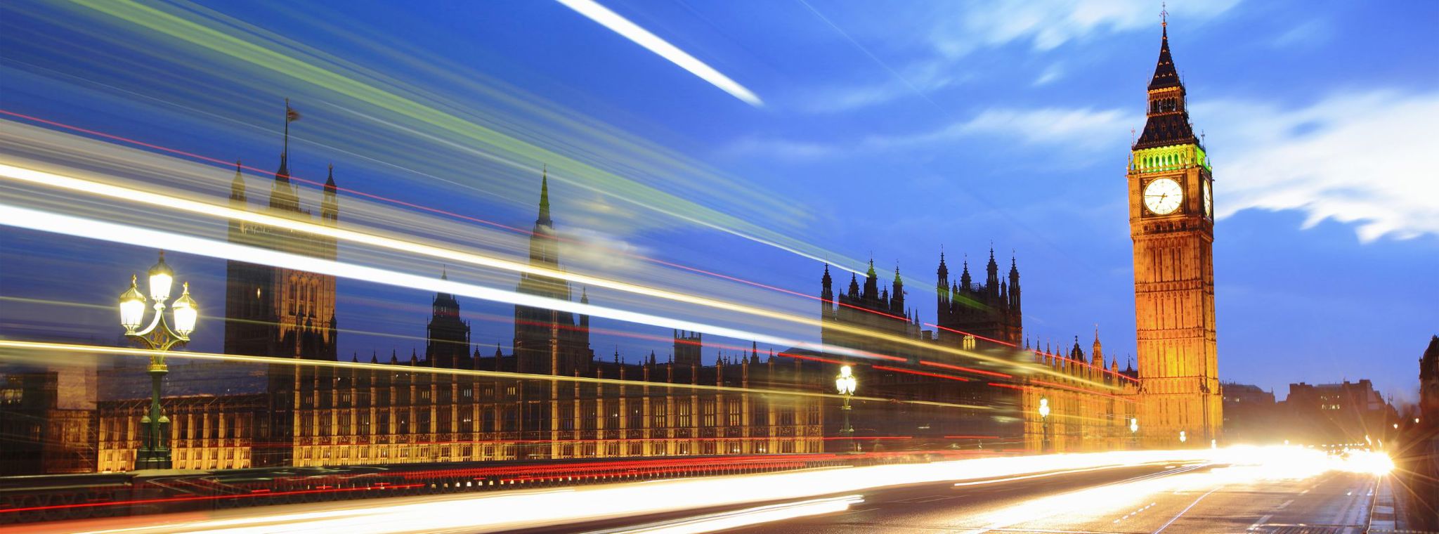 A photo of London Bridge in the evening with a timelapse of traffic passing by, indicating movement