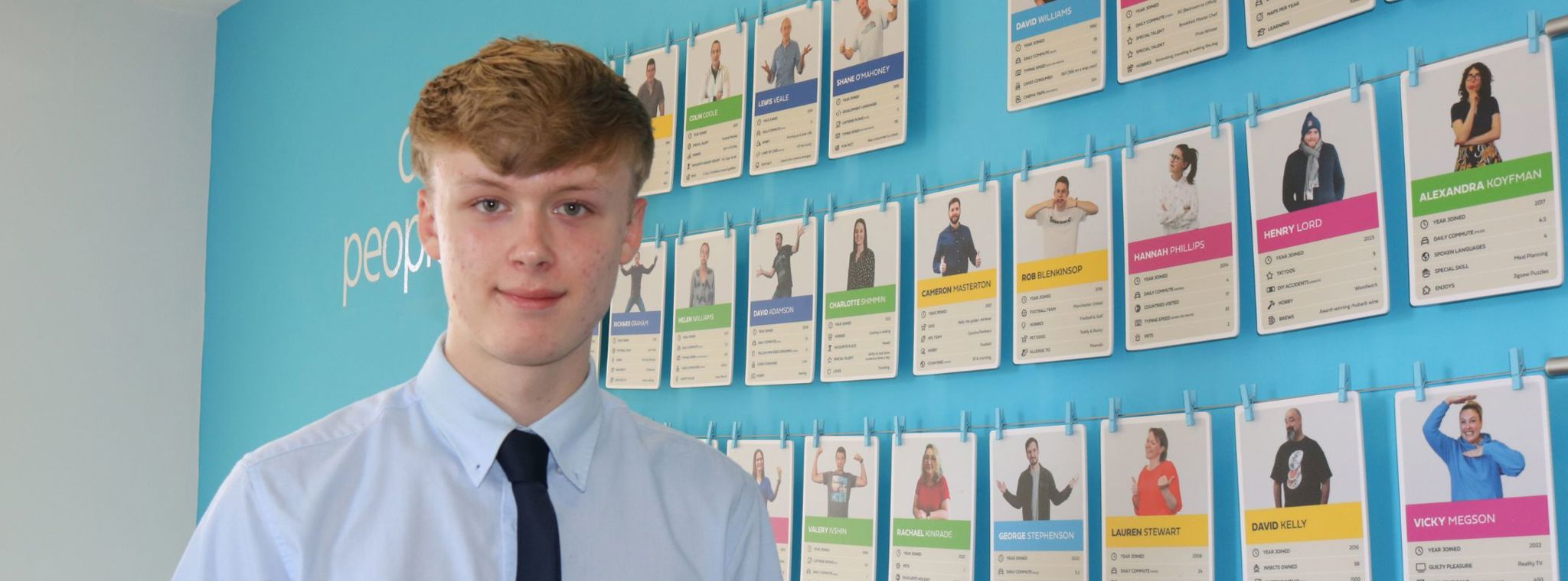 A photo of Pawel Zembrzuski in the PDMS foyer in front of the Our People photo wall