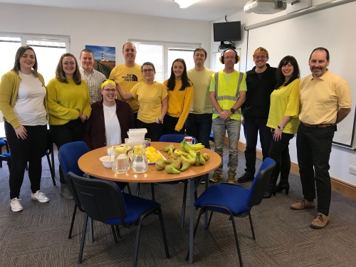 Staff wearing yellow clothes and posing for photo
