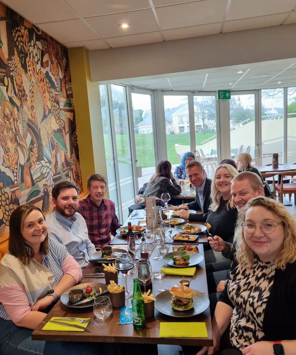 Group of people smiling for photo at a table in a restaurant