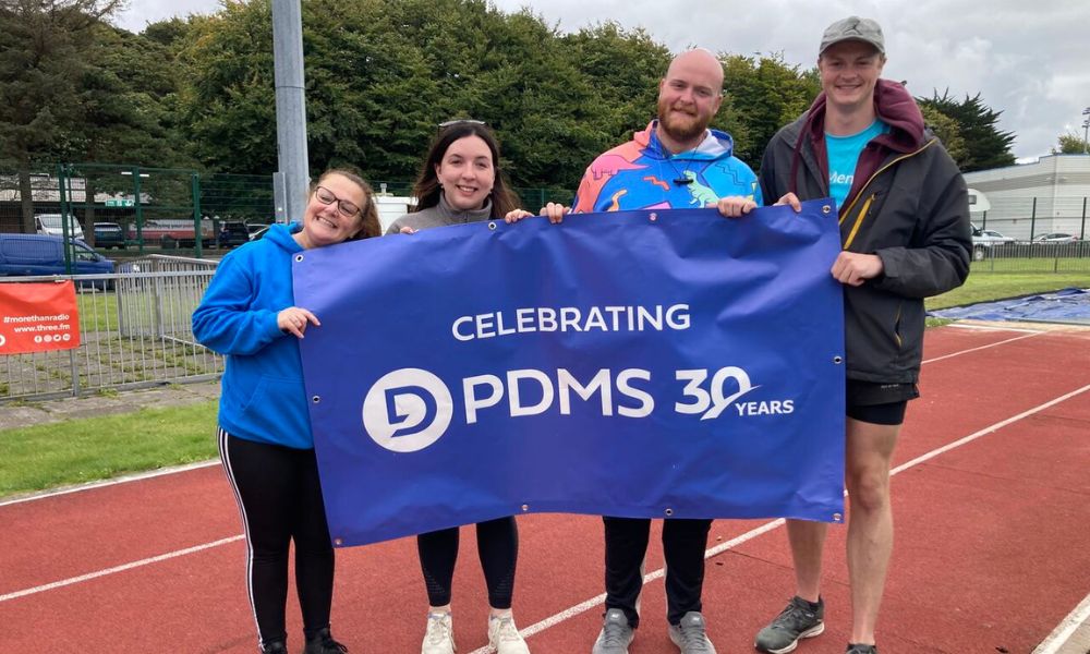 Four people posing with a PDMS 30 years banner at the Relay for Life