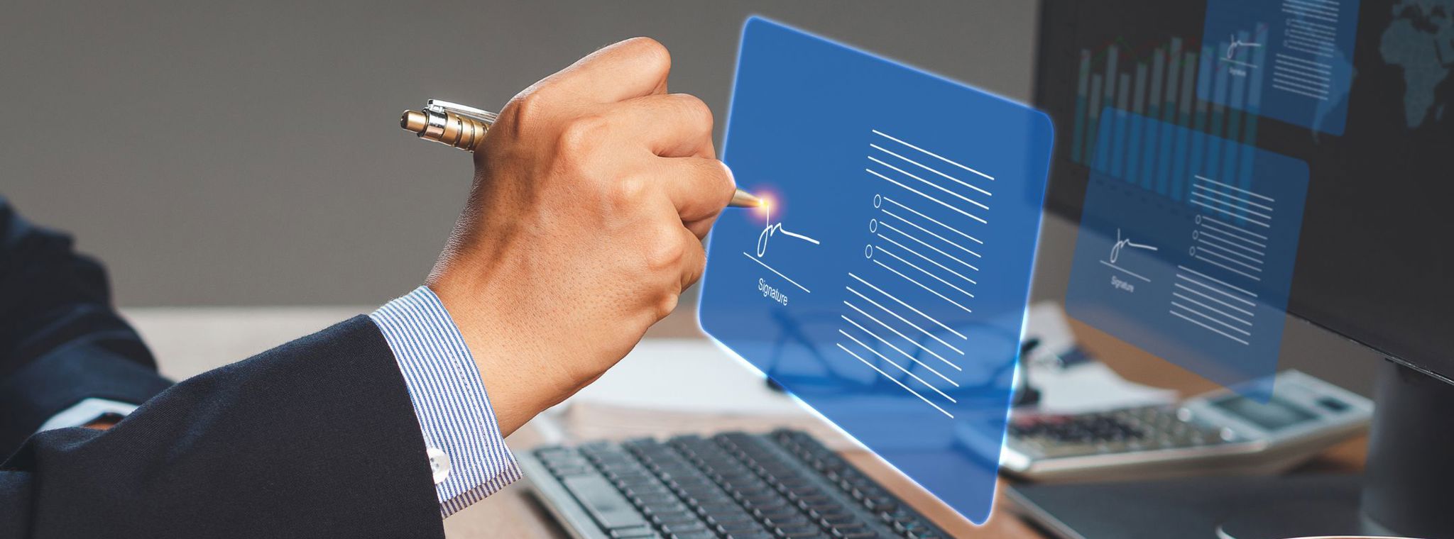 An image of a businessman signing a digital contract in front of a computer