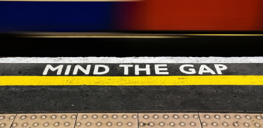 An image of a train station platform with the wording 'Mind the Gap' displayed
