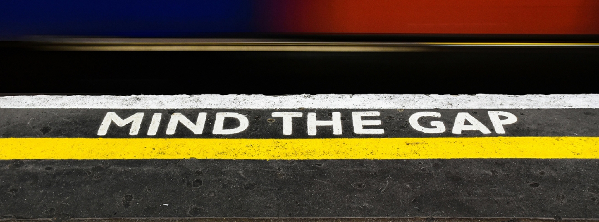 An image of a train station platform with the wording 'Mind the Gap' displayed