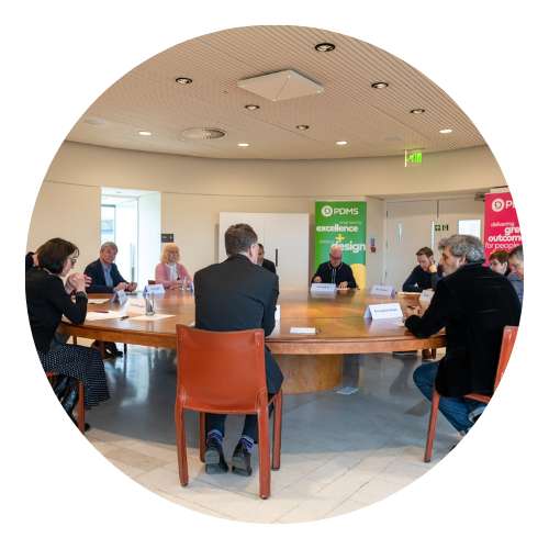 A group of people sat at a roundtable talking