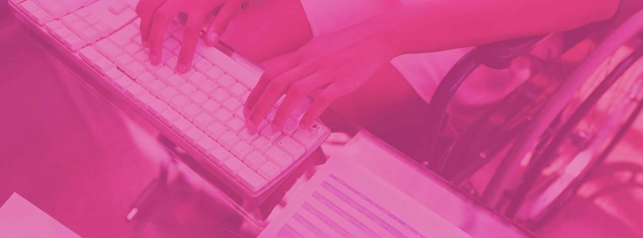 An image of a person in a wheelchair using a computer keyboard