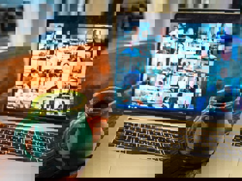 Photo of a laptop screen displaying lots of people on a video call enjoying a webinar