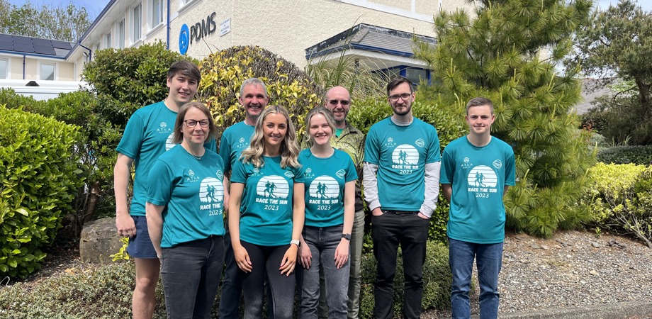 The PDMS team in matching Race the Sun sports t-shirts standing in front of the Isle of Man office