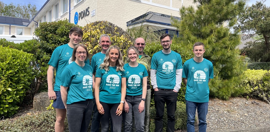 The PDMS team in matching Race the Sun sports t-shirts standing in front of the Isle of Man office