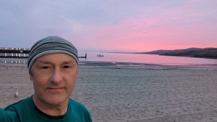 Lewis Veale standing on the beach at sunset in Peel after Race the Sun