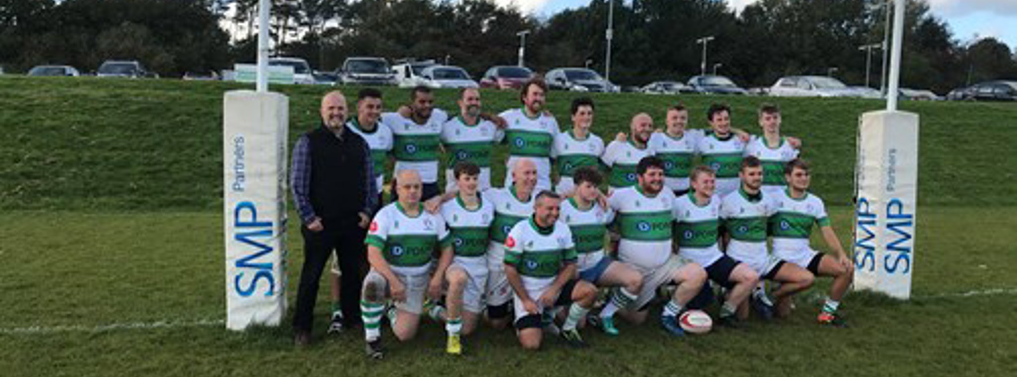 The Southern Nomads rugby team posing underneath the goalposts