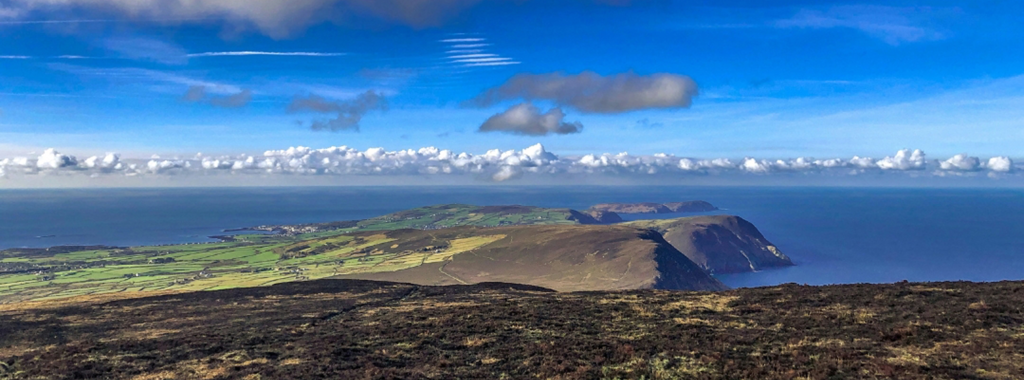A panoramic photo of the south of the Isle of Man with the horizon in the distance