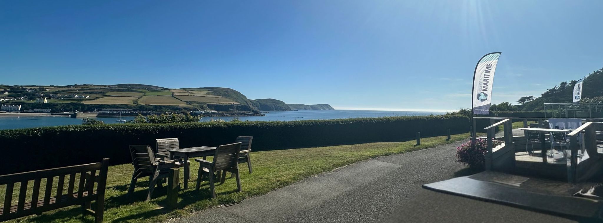 A panoramic photo of Port Erin bay from Bradda Glen with the Isle of Man Maritime flags in the foreground for the IOMM Powerhouse Event