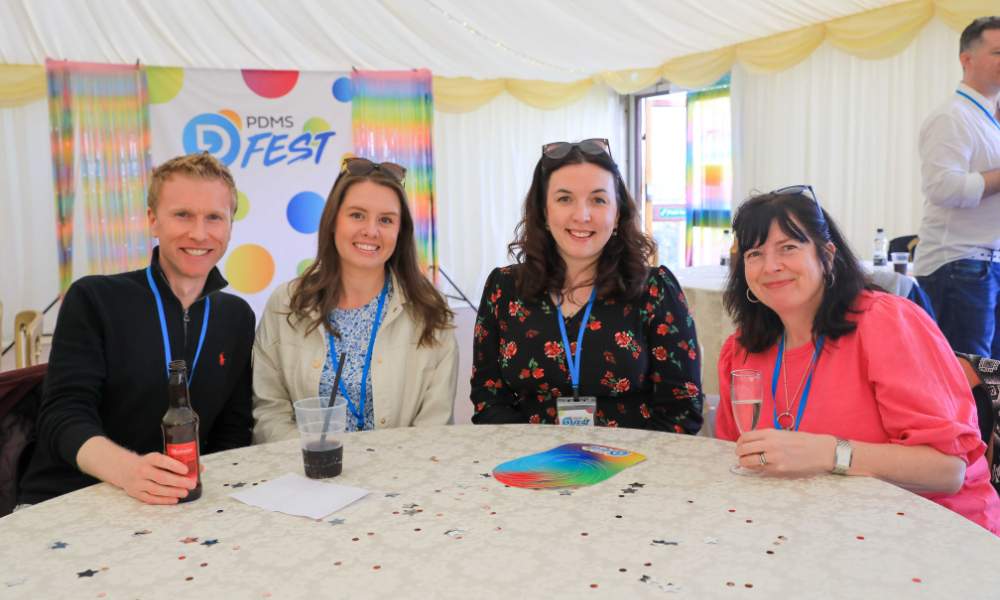 Group of PDMS staff sat at table posing for a photograph