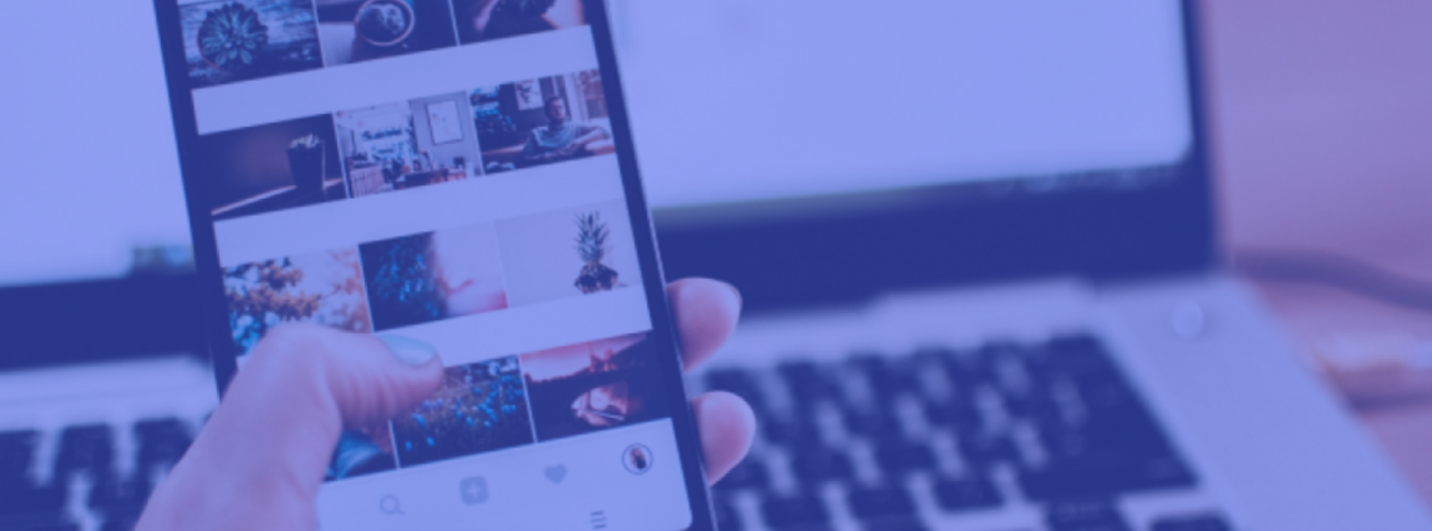 An image of a person holding a mobile phone with images on it in front of a laptop