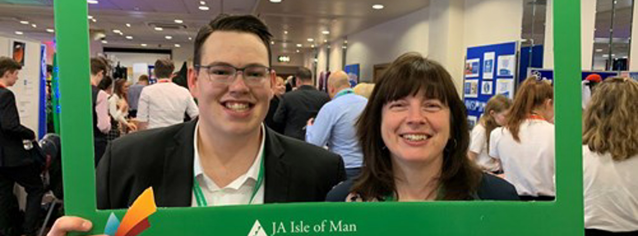Photo of Nick Collins and Joanne Pontee holding green Junior Achievement photo frame