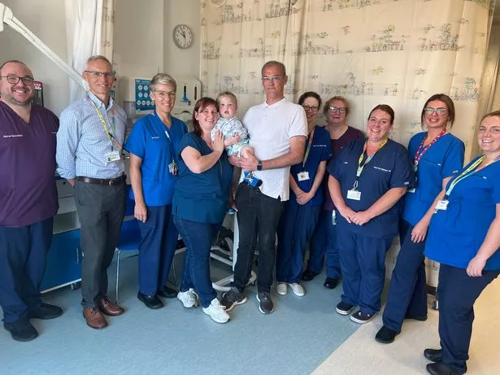 A group of people posing for a photo on a hospital ward