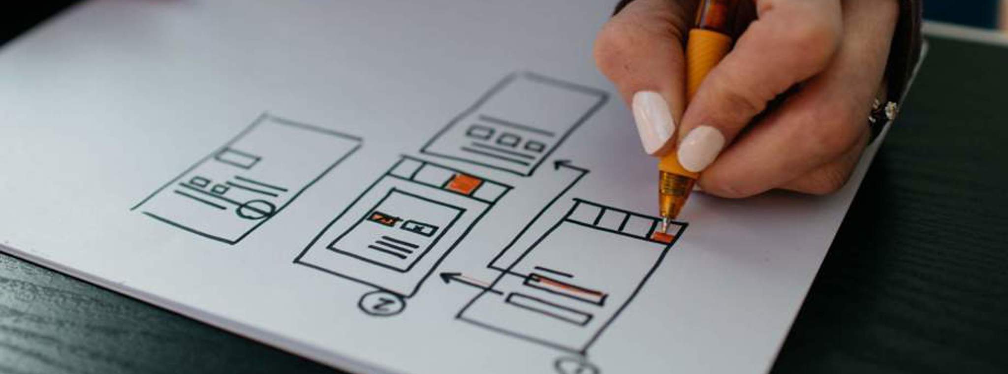 UX designer drawing wireframes on piece of paper
