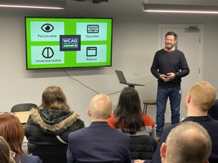 Man providing presentation on accessibility to group of people